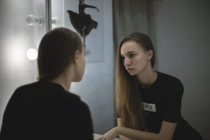 dysmorphophobie: une adolescente devant son miroir